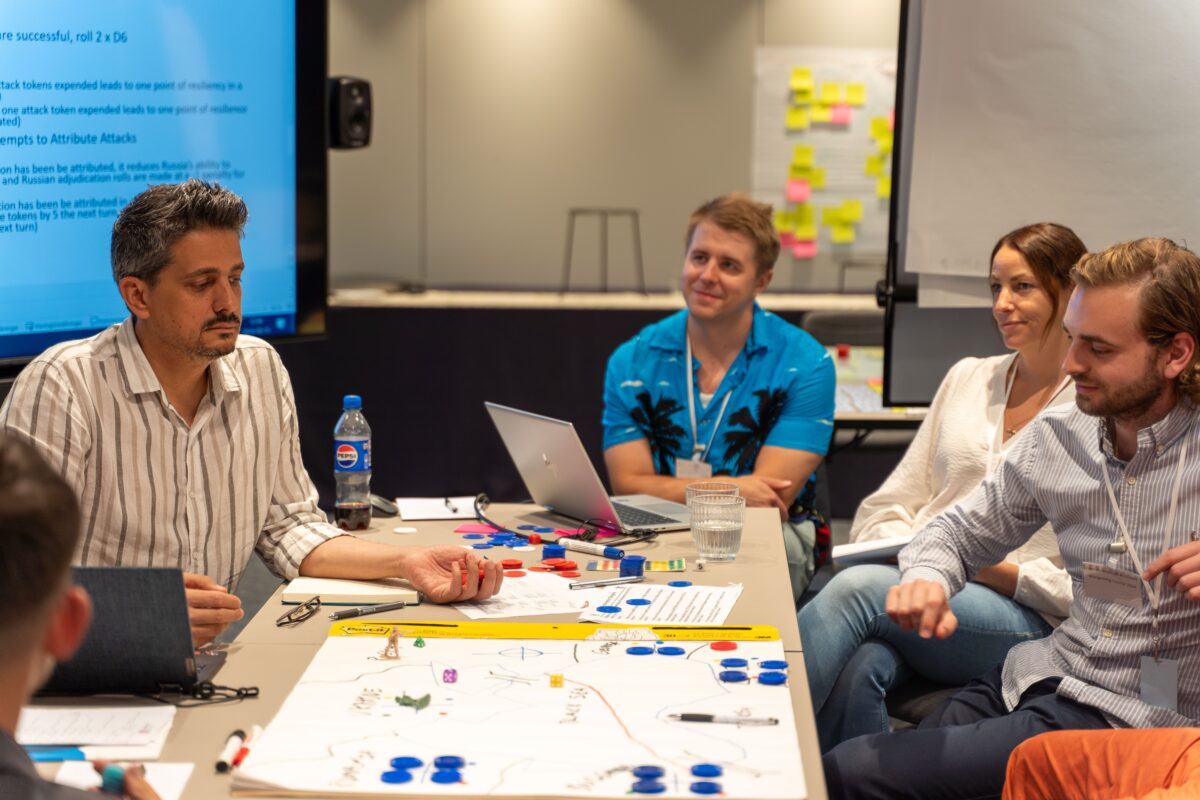 Participants of a wargaming course are playtesting a game developed during the course.